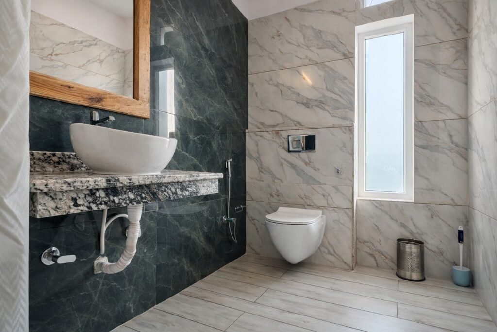 Attached bathroom with washbasin, tiled walls and shower facilities at Om Homestay
