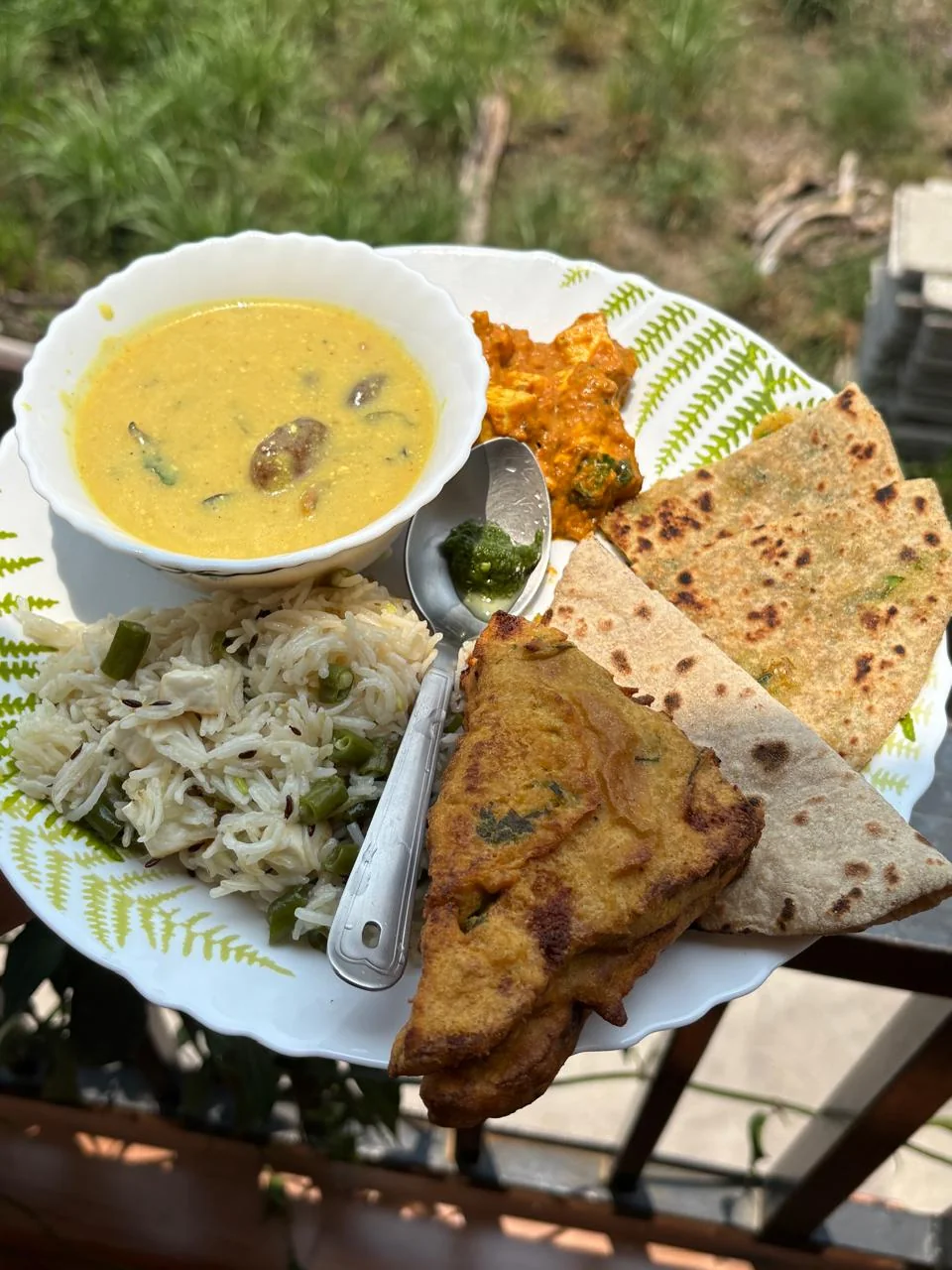 A complete North Indian meal with curry, rice, roti, sweet and drink